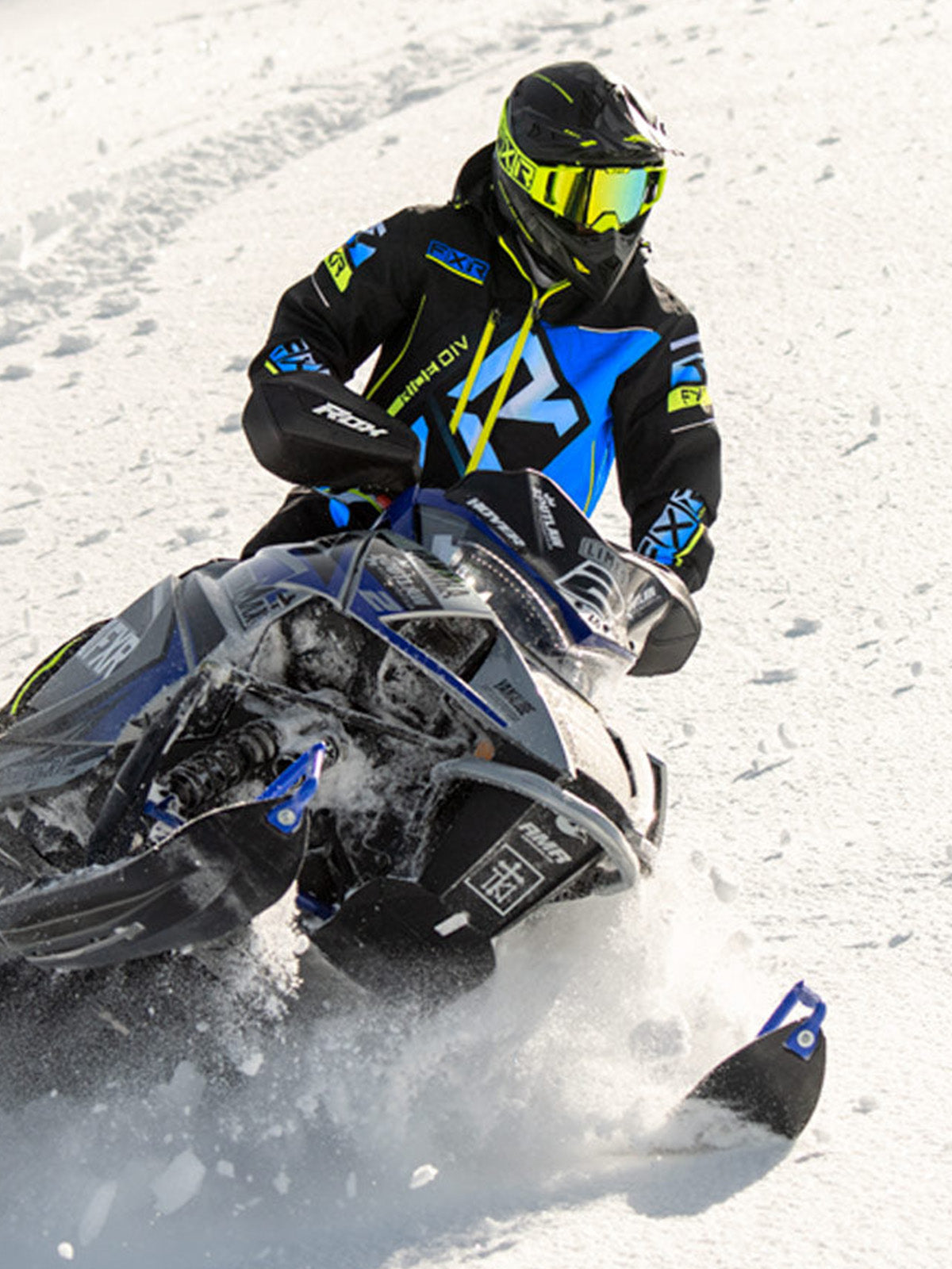 Action image of a guy on a snow mobile wearing an FXR monosuit
