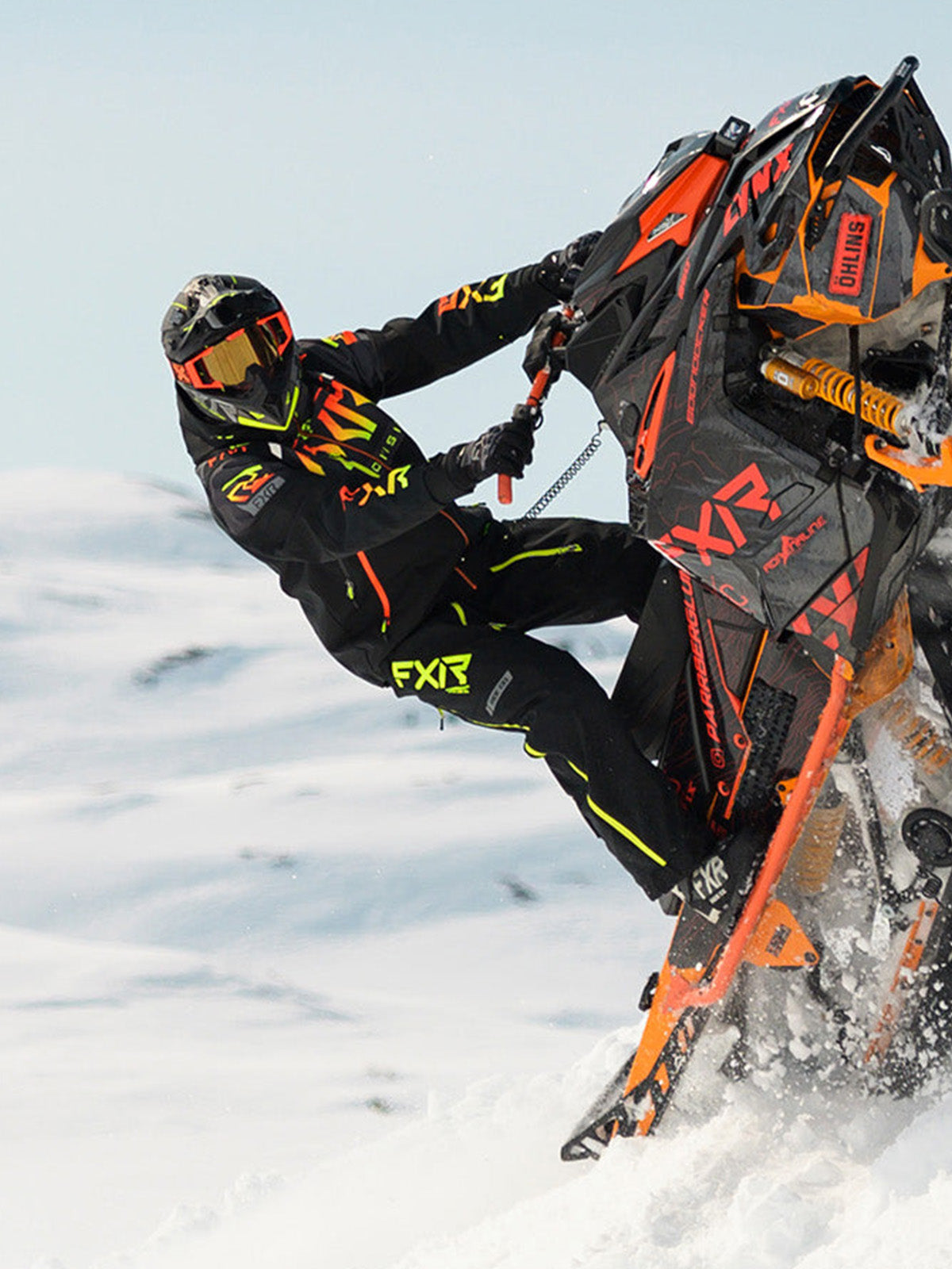 Action image of a guy snowmobiling on the mountain wearing an FXR gear from FXR's Mountain Crossover collection