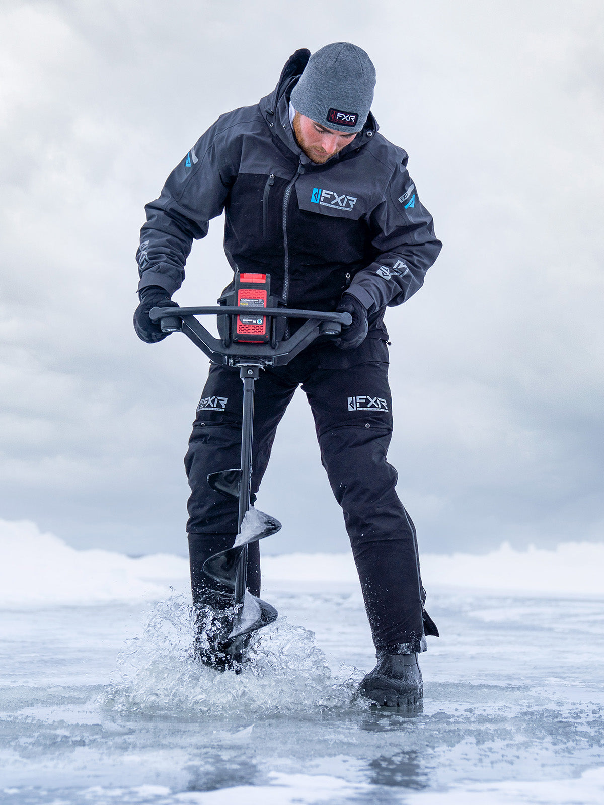 Action image of a guy ice fishing and sporting a gear from FXR's Hard Water Series collection